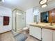 Bright bathroom featuring glass enclosed shower, tile floors and double sink vanity at 1850 Lakeshore Cir, Longwood, FL 32750