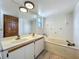 Bathroom featuring double sinks, tub, tiled floor, and window at 1850 Lakeshore Cir, Longwood, FL 32750