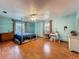 Spacious bedroom featuring hardwood floors, a four-poster bed, dresser, vanity, and bright windows at 1850 Lakeshore Cir, Longwood, FL 32750