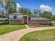 Charming brick home featuring a balcony, arched entryway, and well-manicured lawn at 1850 Lakeshore Cir, Longwood, FL 32750