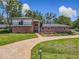 A well-manicured lawn surrounds this inviting two-story brick home with charming details and mature trees at 1850 Lakeshore Cir, Longwood, FL 32750