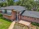 Aerial view of a charming red brick home with lush landscaping and a well-maintained roof at 1850 Lakeshore Cir, Longwood, FL 32750