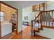 Inviting foyer featuring hardwood floors, open staircase, and a convenient laundry room with ample shelving at 1850 Lakeshore Cir, Longwood, FL 32750