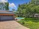 View of the garage and backyard, showing an in-ground pool and fenced yard at 1850 Lakeshore Cir, Longwood, FL 32750