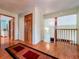 Upstairs hallway featuring hardwood floors, multiple doorways, and staircase at 1850 Lakeshore Cir, Longwood, FL 32750