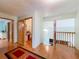 Bright upstairs hallway with hardwood floors and multiple doorways to other rooms in the home at 1850 Lakeshore Cir, Longwood, FL 32750