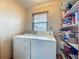 Bright laundry room with washer, dryer, window and shelving at 1850 Lakeshore Cir, Longwood, FL 32750