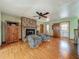 Cozy living room featuring a classic brick fireplace, hardwood floors, and comfortable seating at 1850 Lakeshore Cir, Longwood, FL 32750