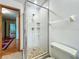 Bright bathroom shower with glass enclosure, white tile, and built-in shelving at 1850 Lakeshore Cir, Longwood, FL 32750