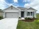 Charming single-story home featuring a two-car garage, neutral tones, and a well-manicured lawn at 1898 Walnut Creek Dr, Kissimmee, FL 34744