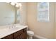 Well-lit bathroom featuring a vanity with dark cabinets and a window with blinds at 207 Spalding Way, Deland, FL 32724