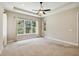 Large bedroom with plenty of natural light, ceiling fan, and tray ceiling at 207 Spalding Way, Deland, FL 32724