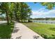 Scenic sidewalk view near the lake surrounded by lush trees offering a peaceful, walkable community at 207 Spalding Way, Deland, FL 32724
