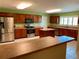 Well-lit kitchen with an island, lots of counter space and cabinetry plus stainless steel appliances and white tile floors at 23717 Milford Dr, Eustis, FL 32736