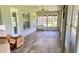 Enclosed lanai featuring wood look floors, fan, and multiple windows overlooking the yard at 23717 Milford Dr, Eustis, FL 32736