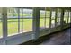 Enclosed lanai featuring wood-look floors and views of the backyard and waterway at 23717 Milford Dr, Eustis, FL 32736