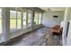 Enclosed lanai with wood look floors, chair, fan, and windows providing backyard views at 23717 Milford Dr, Eustis, FL 32736