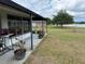Covered patio, ideal for relaxing outdoors, offering a beautiful view of the spacious backyard and the serene lake at 23717 Milford Dr, Eustis, FL 32736