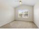 A bright bedroom with a neutral carpet, a ceiling fan, and a window view at 2420 Stockton Dr, Sanford, FL 32771