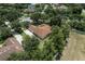 Aerial view of a home surrounded by mature trees, featuring a brown roof and a spacious front lawn at 2426 Breezy Meadow Rd, Apopka, FL 32712