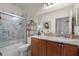 Bathroom with marble accents in the shower and countertop with wood cabinets at 2426 Breezy Meadow Rd, Apopka, FL 32712