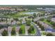 Aerial view of a residential neighborhood with mature trees, pond, and community amenities at 2669 Manesty Ln, Kissimmee, FL 34747