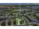 A peaceful neighborhood aerial view highlights a serene pond and houses with screened-in pools at 2669 Manesty Ln, Kissimmee, FL 34747