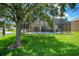 Backyard view showcasing a screened-in pool and patio area and mature trees at 2669 Manesty Ln, Kissimmee, FL 34747