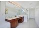 Bright bathroom featuring a double vanity, clean white walls and a tiled floor at 2669 Manesty Ln, Kissimmee, FL 34747