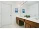 Bright bathroom featuring a double vanity, clean white walls and a tiled floor at 2669 Manesty Ln, Kissimmee, FL 34747