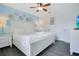 Well-lit bedroom with a blue accent wall, a comfortable white bed, and stylish decor at 2669 Manesty Ln, Kissimmee, FL 34747
