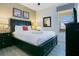 Inviting bedroom featuring a black bed frame, wood floors, and neutral-toned walls at 2669 Manesty Ln, Kissimmee, FL 34747