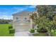 Charming two-story home with a well-maintained lawn and a tree in the front yard at 2669 Manesty Ln, Kissimmee, FL 34747