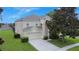 Two-story home with a well-manicured lawn and a two-car garage at 2669 Manesty Ln, Kissimmee, FL 34747