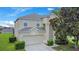 Charming two-story home with a well-maintained lawn and a tree in the front yard at 2669 Manesty Ln, Kissimmee, FL 34747