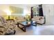 A well-lit living room featuring stylish furnishings, neutral-toned sofas, and a glass coffee table at 2669 Manesty Ln, Kissimmee, FL 34747