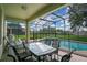 Inviting pool area with a covered patio, dining area, and lush green surroundings at 2669 Manesty Ln, Kissimmee, FL 34747