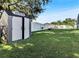 A spacious backyard featuring a large storage shed with a white privacy fence and green grass at 2919 Foraker Way, Kissimmee, FL 34758