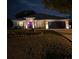 Charming home exterior at night with well-lit landscaping, a two-car garage, and inviting curb appeal at 2919 Foraker Way, Kissimmee, FL 34758