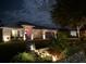 Inviting home exterior at night features professional landscape lighting and an attractive water feature at 2919 Foraker Way, Kissimmee, FL 34758