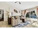 Inviting living room featuring a comfortable sectional sofa, area rug, and sliding glass doors leading to the pool area at 2919 Foraker Way, Kissimmee, FL 34758