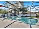 Backyard swimming pool under a screened enclosure, featuring a fountain and stylish decor at 2919 Foraker Way, Kissimmee, FL 34758