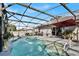 A serene screened-in pool area with solar panels, outdoor dining, and a red sun umbrella at 2919 Foraker Way, Kissimmee, FL 34758