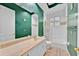 Bathroom featuring green walls, a large mirror, a combination tub and shower, and a sink with storage at 307 Running Wind Ln, Maitland, FL 32751