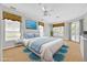 Bright bedroom with a large bed, windows, and ceiling fan, virtually staged with blue accents at 307 Running Wind Ln, Maitland, FL 32751