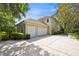 Side view of the house showcasing a three-car garage and spacious concrete driveway at 307 Running Wind Ln, Maitland, FL 32751