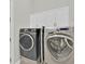 Laundry room with two modern machines and upper cabinets for storage at 307 Running Wind Ln, Maitland, FL 32751