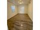 Cozy bedroom featuring wood-look flooring and bright windows at 31538 Anderson Dr, Tavares, FL 32778