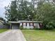 Charming single-story home featuring a carport and a well-maintained front yard at 31538 Anderson Dr, Tavares, FL 32778