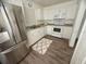 Bright kitchen featuring white cabinets, modern appliances, and wood-look flooring at 31538 Anderson Dr, Tavares, FL 32778